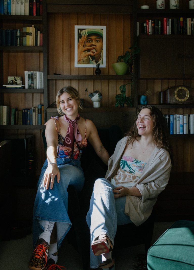 Lotta Falter und Lisa Schubert, systemische Therapeutinnen in Mannheim, sitzen an einem Tisch und lachen